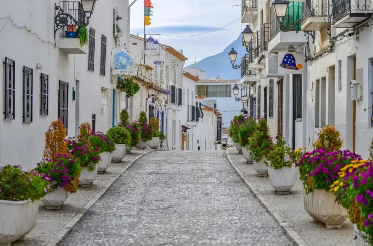 Calle típica de Altea con fachadas blancas y macetas floridas.