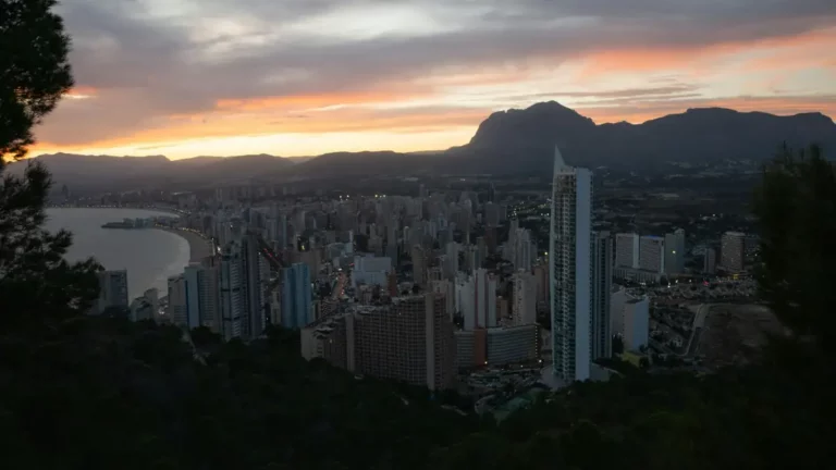 Benidorm al atardecer con sus rascacielos y la playa de Poniente.